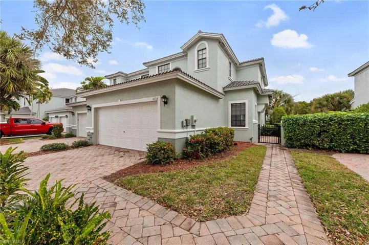Mediterranean / spanish home featuring a gate, stucco siding, decorative driveway, a tiled roof, and a garage