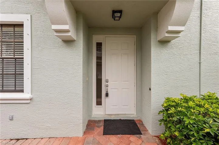 Doorway to property featuring stucco siding