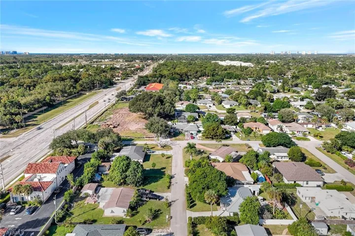 Aerial view of property and surrounding area with nearby suburban area
