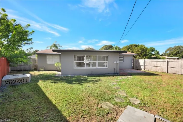Rear view of property with a fenced backyard and stucco siding