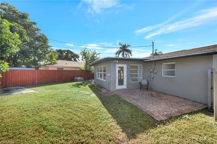 Rear view of house featuring a patio area, stucco siding, and a fenced backyard