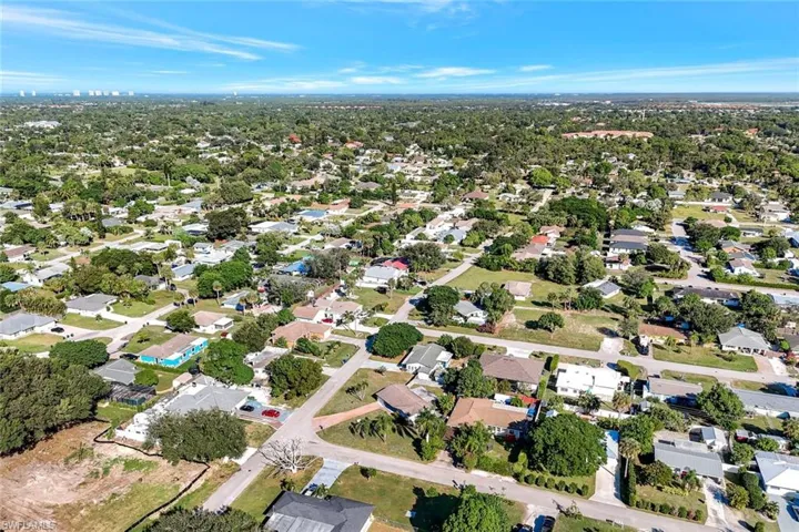 Aerial view of property and surrounding area featuring nearby suburban area