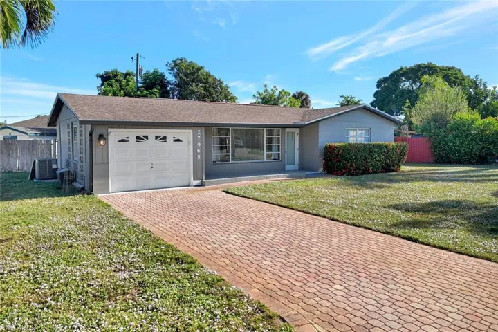 Ranch-style house featuring an attached garage and decorative driveway