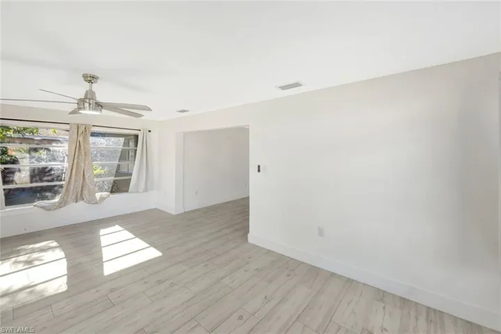Spare room with wood finished floors and a ceiling fan