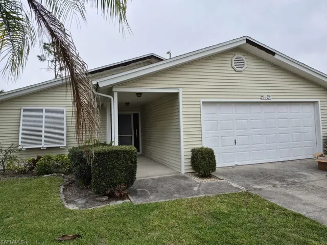 Ranch-style house with concrete driveway, an attached garage, and a front yard