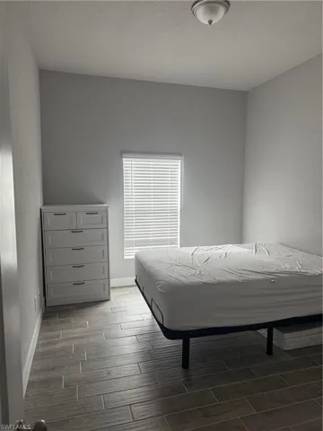 Bedroom with dark hardwood / wood-style floors