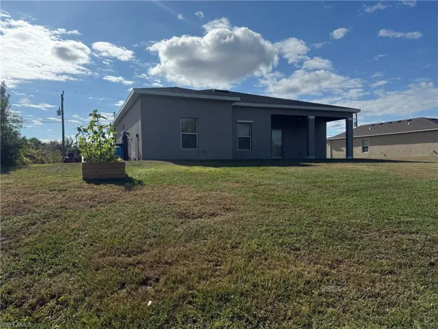 Back of house featuring a lawn