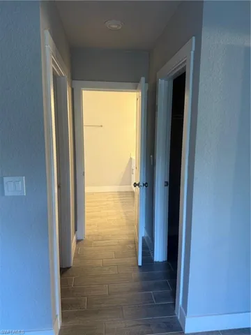 Hallway with dark hardwood / wood-style floors