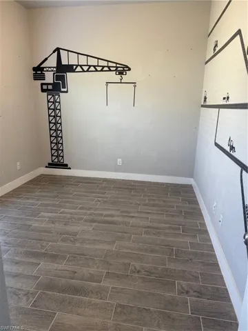 Empty room featuring dark hardwood / wood-style flooring