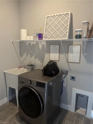 Laundry area featuring dark hardwood / wood-style flooring and washer / clothes dryer