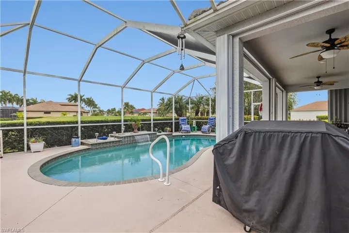 View of pool featuring a grill, glass enclosure, a patio area, and ceiling fan