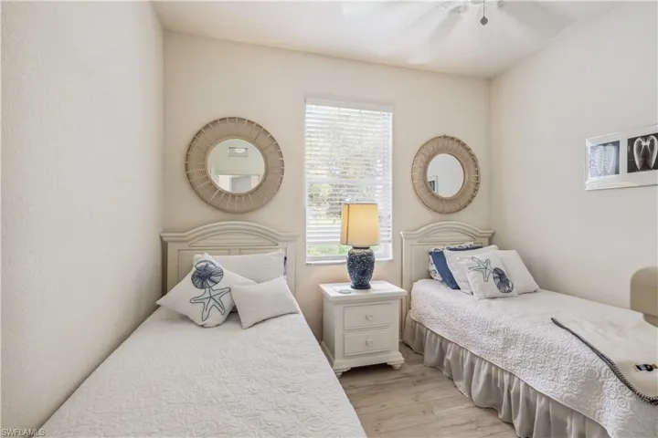 Bedroom with light hardwood / wood-style flooring, ceiling fan, and multiple windows