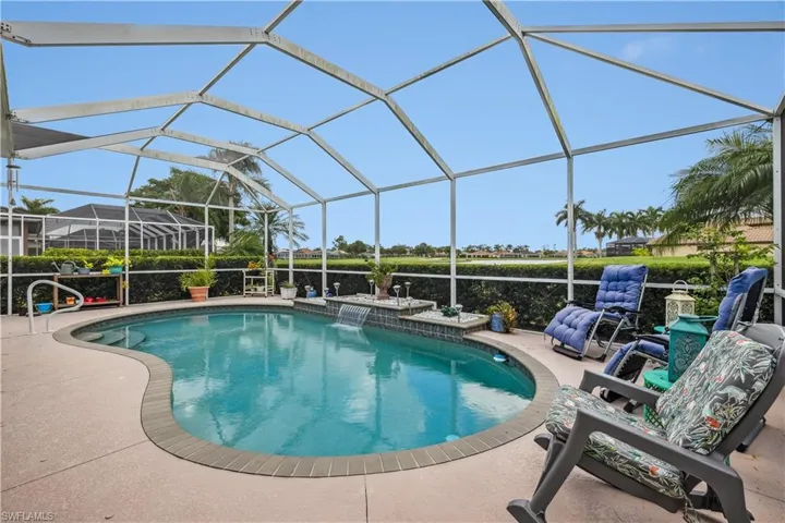 View of swimming pool featuring pool water feature, a lanai, and a patio