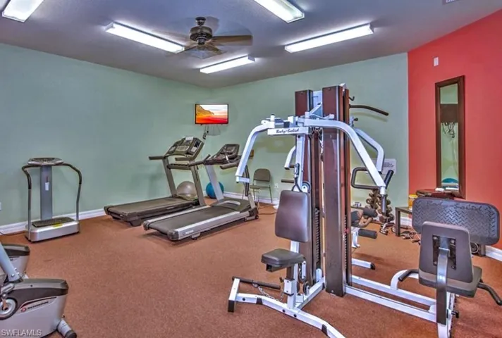 Workout area featuring a ceiling fan and baseboards