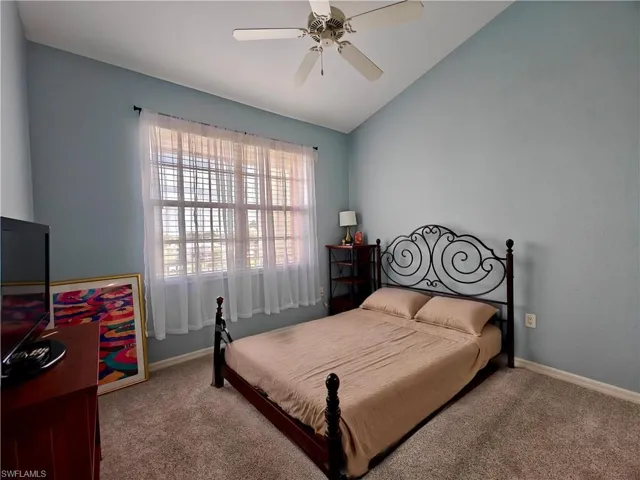 Bedroom featuring vaulted ceiling, carpet, and ceiling fan