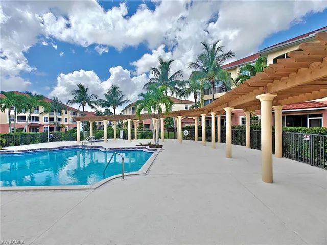 Community pool with a pergola and a patio area