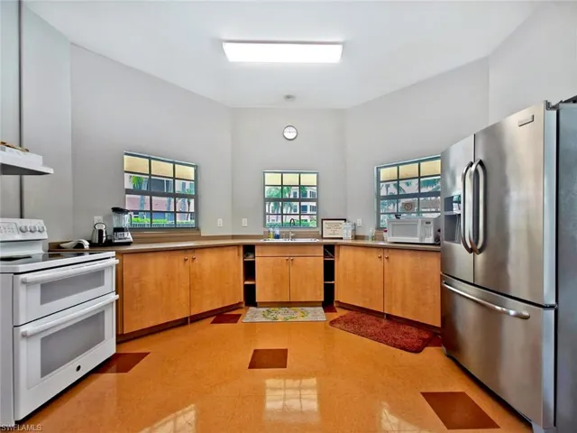 Kitchen featuring white appliances and brown cabinets