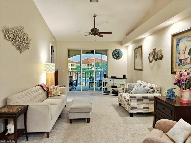 Carpeted living area featuring a ceiling fan