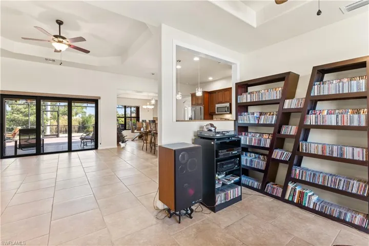Tiled office with ceiling fan and a tray ceiling