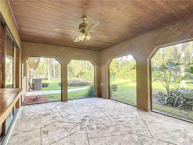 Unfurnished sunroom featuring ceiling fan and wooden ceiling