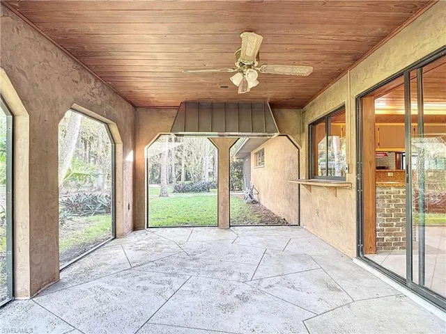 Unfurnished sunroom with ceiling fan and wooden ceiling