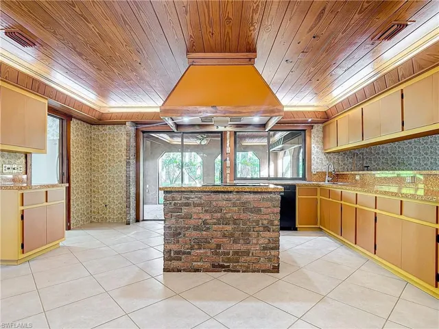 Living room featuring wooden ceiling, beamed ceiling, a healthy amount of sunlight, and wood walls