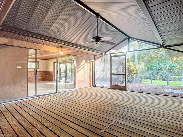 Master Bedroom featuring ceiling fan, light tile patterned floors, and wooden walls