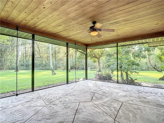 Unfurnished sunroom with ceiling fan and vaulted ceiling