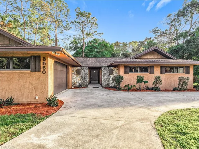 View of front of house with a garage and a front lawn