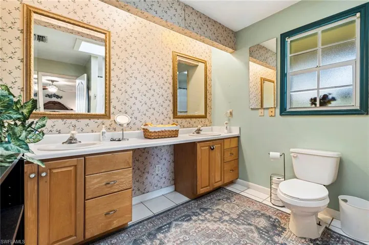 Full bath with double vanity and light tile patterned flooring
