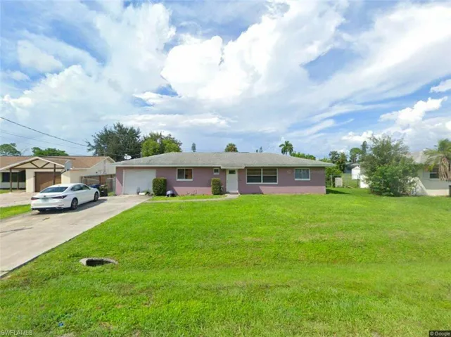 Single story home featuring a garage and a front yard