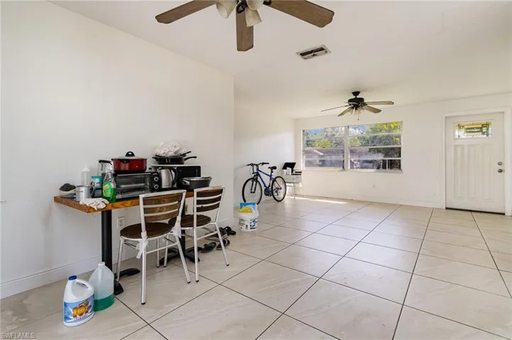 Office featuring light tile patterned floors, baseboards, visible vents, and ceiling fan