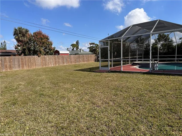 View of yard featuring a lanai and a fenced in pool