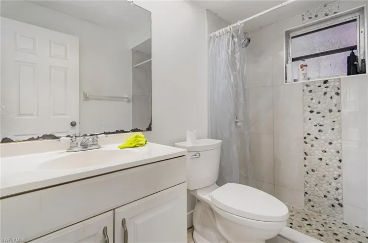 Full bathroom featuring a shower stall, vanity, and toilet