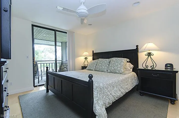 Bedroom featuring access to exterior, light wood finished floors, and a ceiling fan