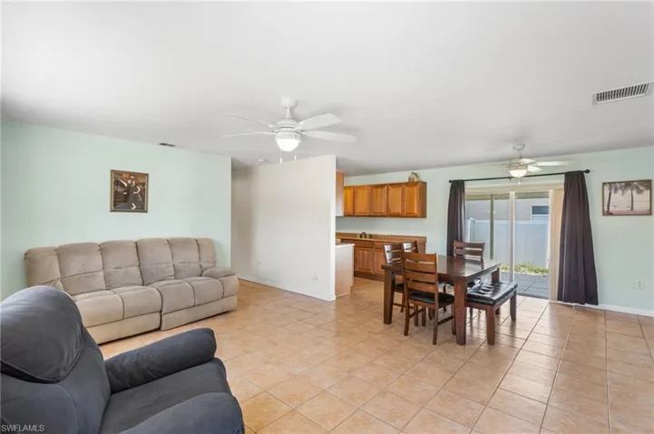 Living room with ceiling fan and light tile patterned floors