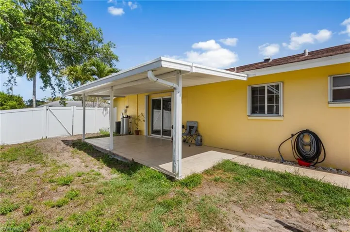 Rear view of property with a patio, stucco siding, and a gate