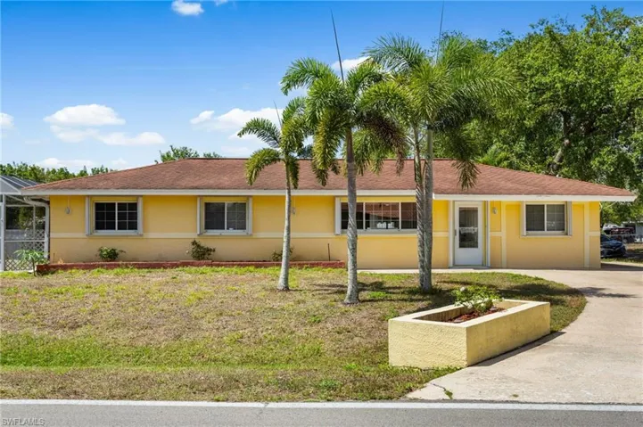 Ranch-style home with stucco siding, concrete driveway, screened pool cage.