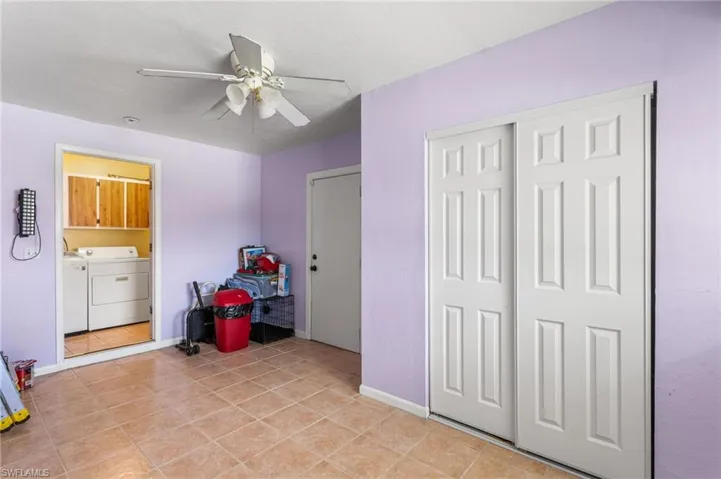 Separate entrance bedroom with ceiling fan, a closet, and connected to laundry room.
