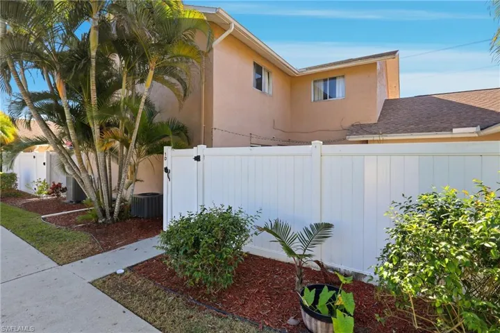 View of home's exterior with stucco siding and a gate