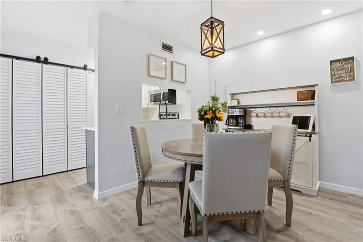 Dining room with a barn door and light wood-type flooring