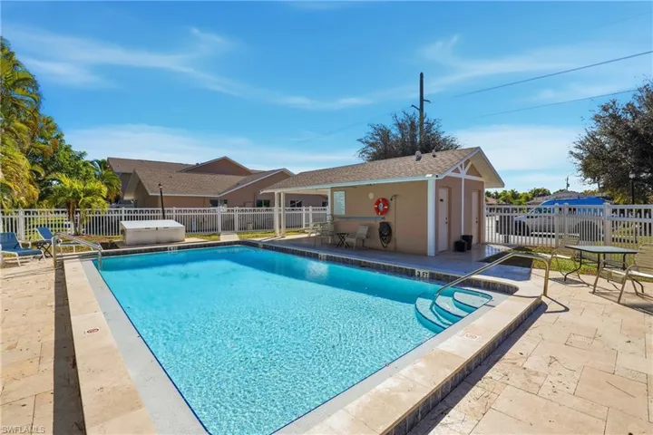 Community pool featuring a patio and an outbuilding