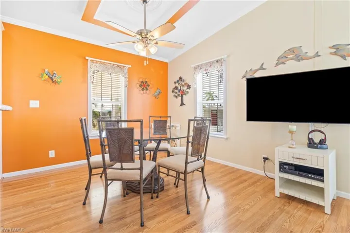 Dining room with ceiling fan, ornamental molding, and light hardwood / wood-style flooring