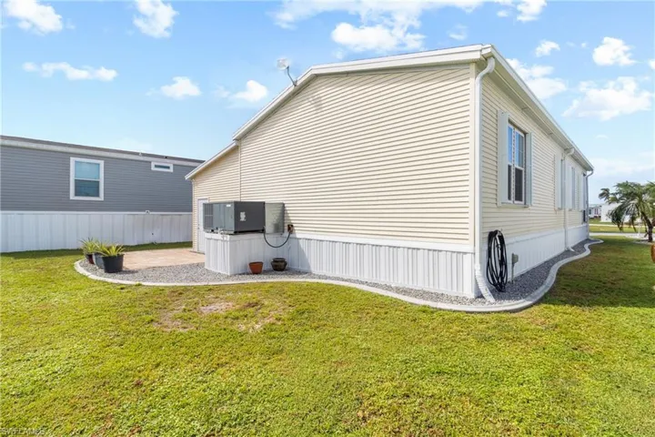 View of property exterior with cooling unit and a lawn