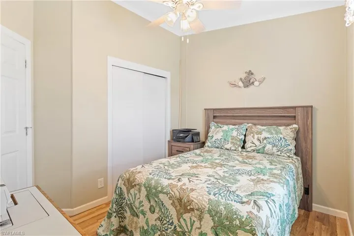 Bedroom with light hardwood / wood-style flooring, a closet, and ceiling fan
