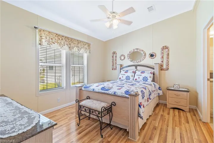 Bedroom with light hardwood / wood-style floors, crown molding, and ceiling fan