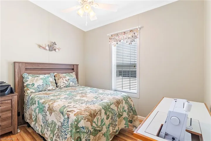 Bedroom with light hardwood / wood-style floors, ornamental molding, and ceiling fan