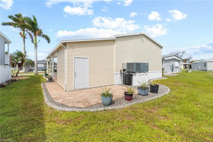 Rear view of house with a patio area and a lawn