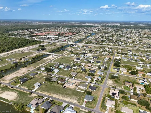 Aerial view of property and surrounding area with nearby suburban area