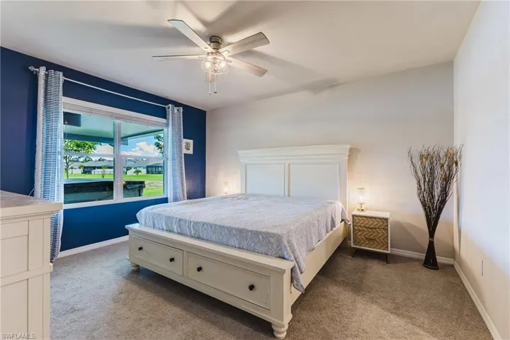 Vaulted ceilings, a wide window, and a ceiling fan with integrated lighting